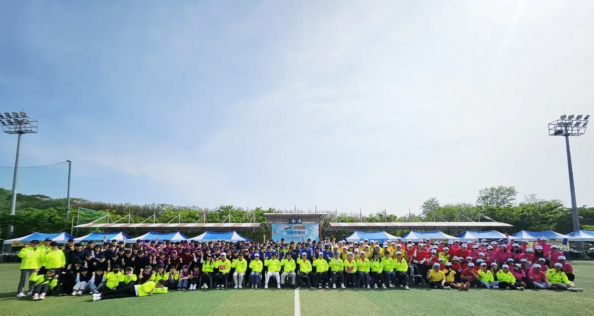 2026년 4월 중구 다목적구장에서 팀별 색깔 단체복을 입은 회원들이 운동장에 늘어선 명랑운동회 단체 사진